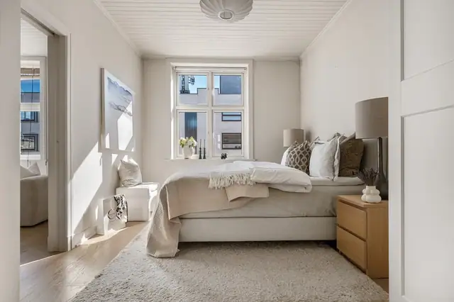 Soverommet fremstår som lyst og rolig, med store vindusflater som slipper inn rikelig med naturlig lys.