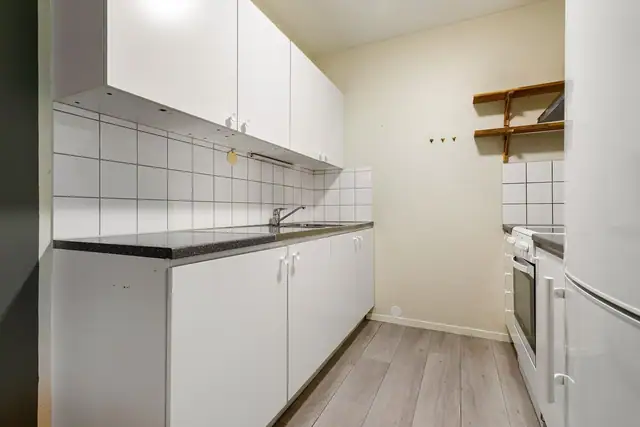 Kjøkkenet har glatte fronter og benkeplate i laminat med beslag i rustfritt stål og dobbel oppvaskkum med svingbart blandebatteri.