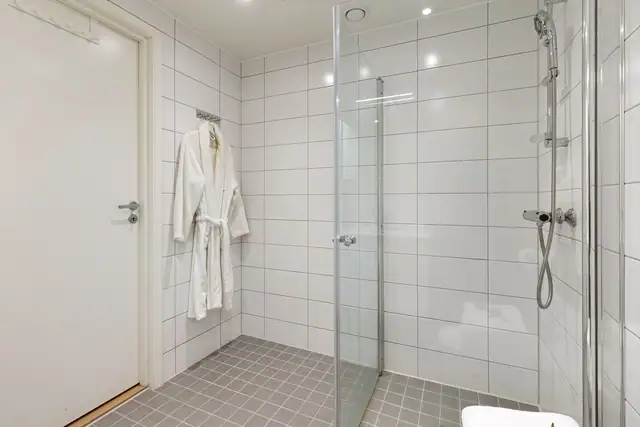 Badet er utstyrt med dusjhjørne med innfellbare dusjdører og blandebatteri fra FM Mattsson.