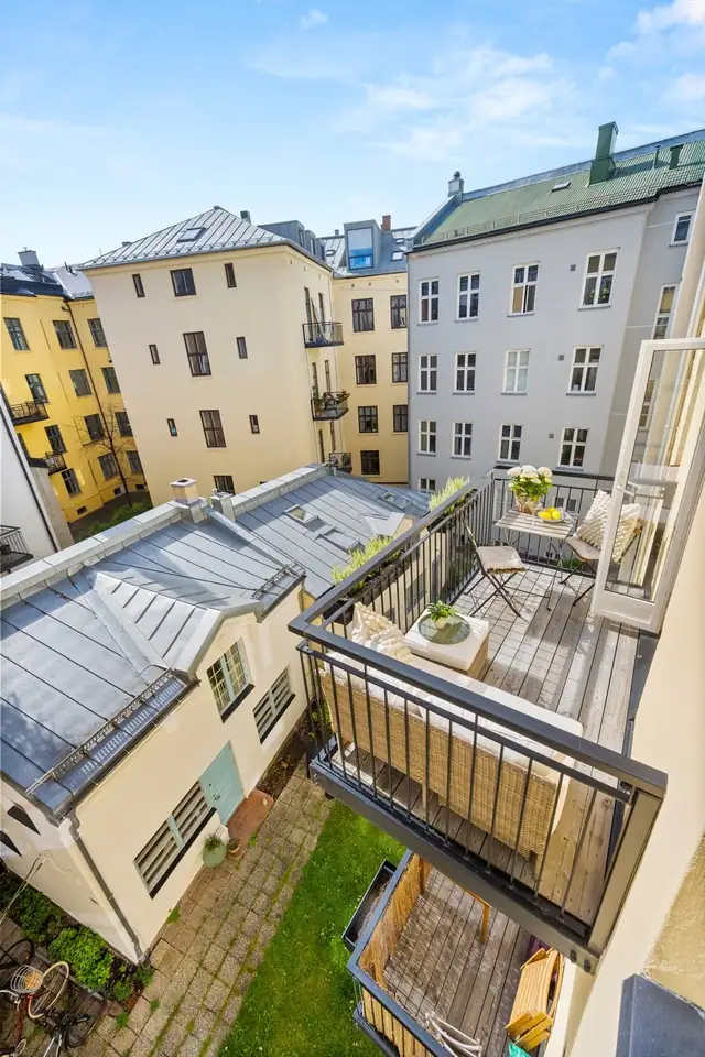 Balkongen vender mot idyllisk bakgård.