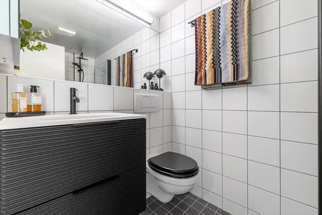 Badet har flislagte overflater og behagelig gulvvarme. Det er opplegg for vaskemaskin og mekanisk ventilasjon.