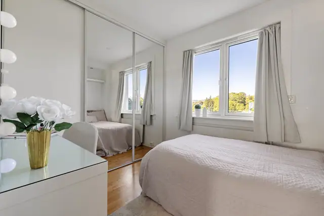 Rommet er innredet med en stor skyvedørsgarderobe.