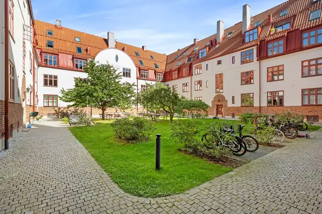 Bakgården er tilbaketrukket fra gaten og omkranset av klassiske bygårder, noe som gir en lun og trygg atmosfære - nesten som en liten park bare for beboerne.