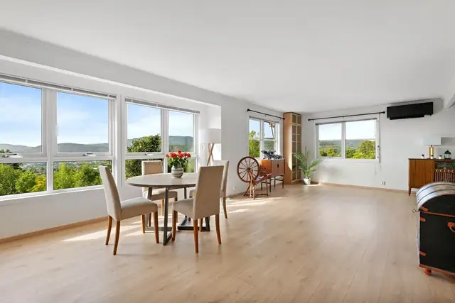 Romslig stue med store vindusflater som slipper rikelig inn med naturlig lys.