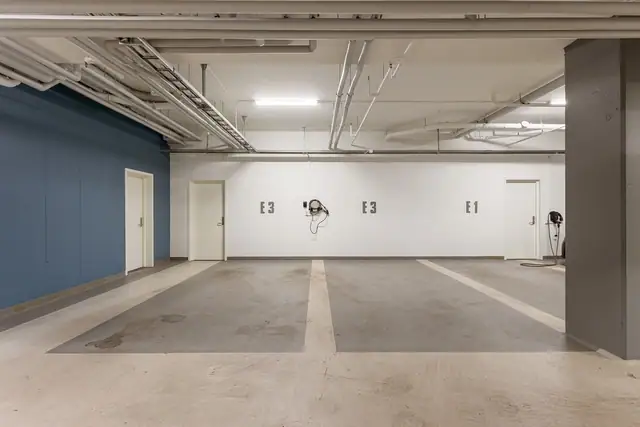 Det medfølger to parkeringsplasser i felles garasjeanlegg, begge markert E3. Parkeringsplassene har en delt elbillader. Begge plassene har samlet en bredde og lengde på ca. 4,9m. Videre er det direkte adkomst til bod på 24 kvm innenfor garasjeplassene.