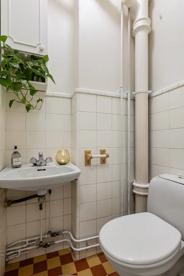 Det er et eget toalettrom som er innredet med gulvstående toalett, servant og vegghengt skap.