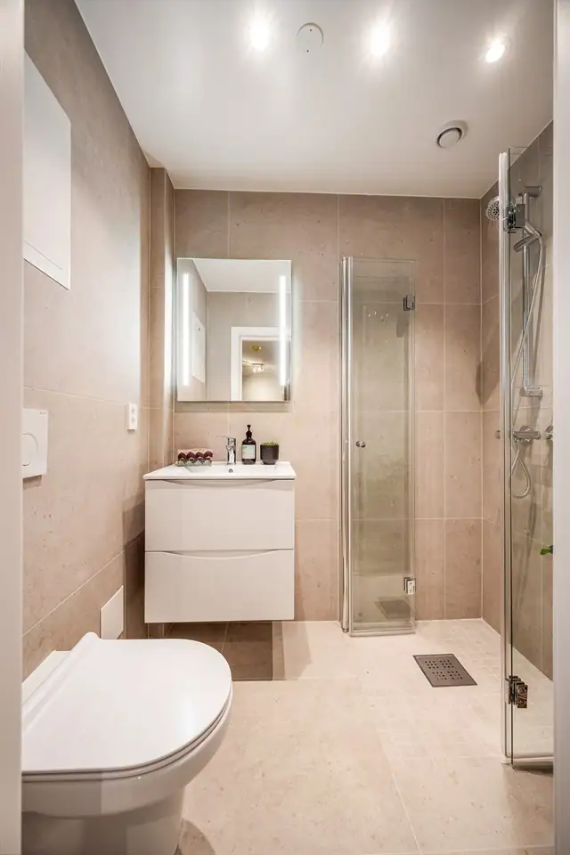 Nytt bad pusset opp av BOVG Bygg og Våtrom AS i 2026. Badet har tidsriktige farge- og materialvalg med flislagte overflater, elektriske varmekabler og downlights.