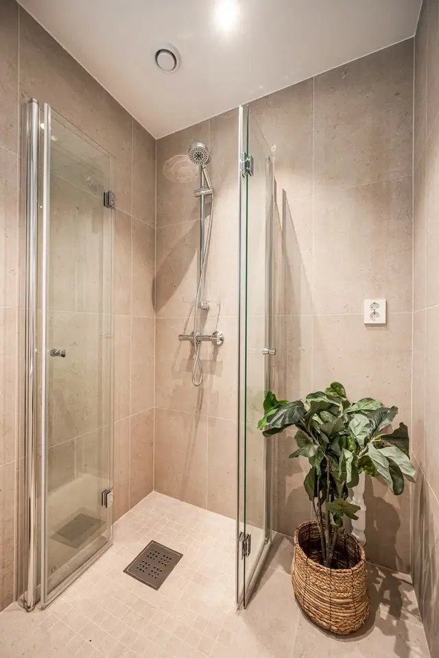 Badet er innredet med dusjhjørne med innfellbare glassdører og blandebatteri. Baderomsinnredningen består av servantskap med heldekkende servant, ettgreps blandebatteri og speil. Opplegg for smal oppvaskmaskin.