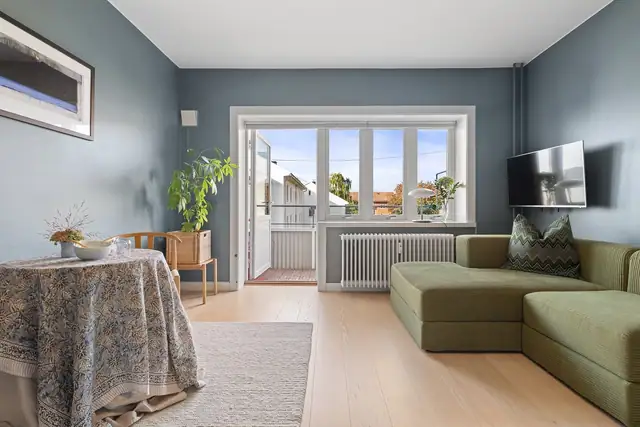 Stuen har store vindusflater som slipper inn rikelig med naturlig lys, mens takhøyden på 2,63 meter bidrar til en luftig og behagelig romfølelse.